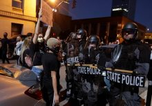 Viral photo shows Louisville cop protected by black protesters when separated from squad during riot